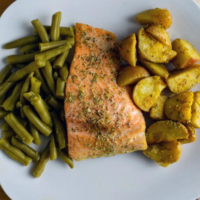Baked salmon fillet with green beans and sliced almonds on a plate