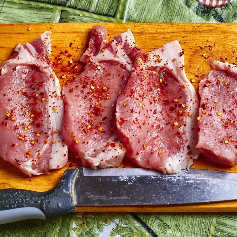 Seared pork chops with sauteed apple and onion slices in a skillet