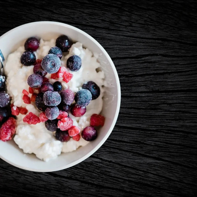 A bowl of cottage cheese salad studded with halved grapes, diced celery and chopped pecans