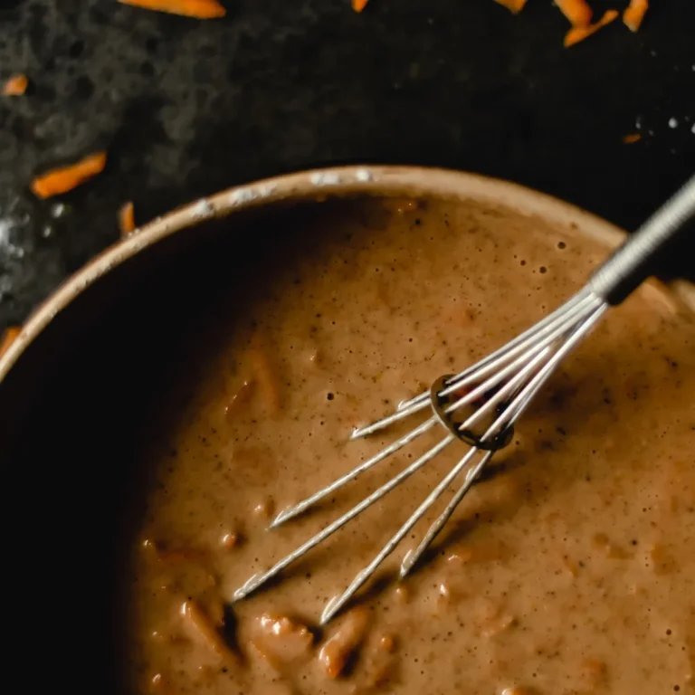 A slice of golden carrot baked oatmeal flecked with grated carrot on a plate