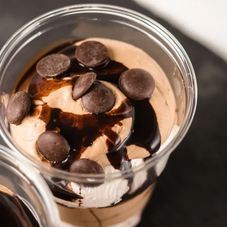 A small glass of dark chocolate peanut butter mousse topped with a swirl of peanut butter