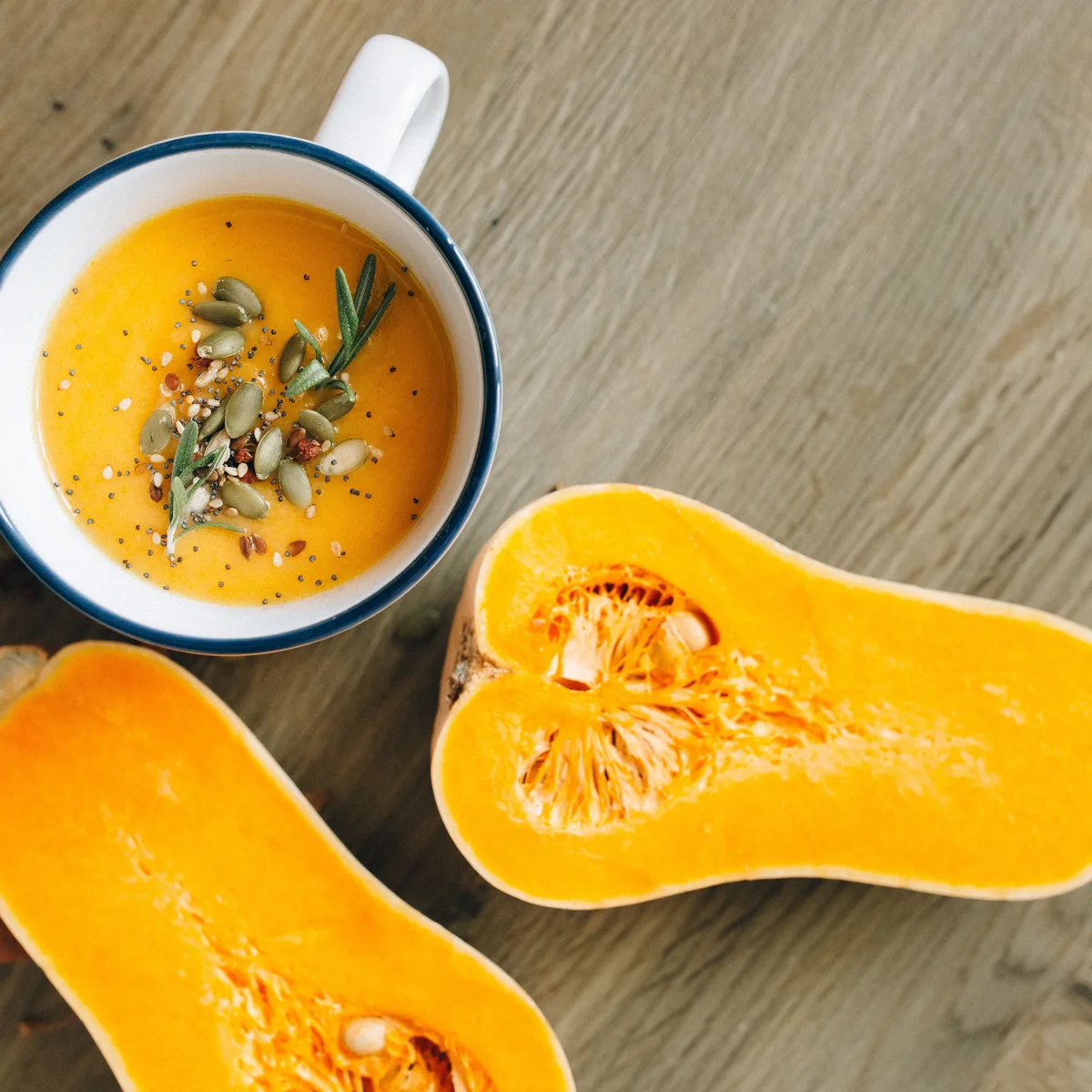 A bowl of smooth blended butternut squash soup topped with seeds