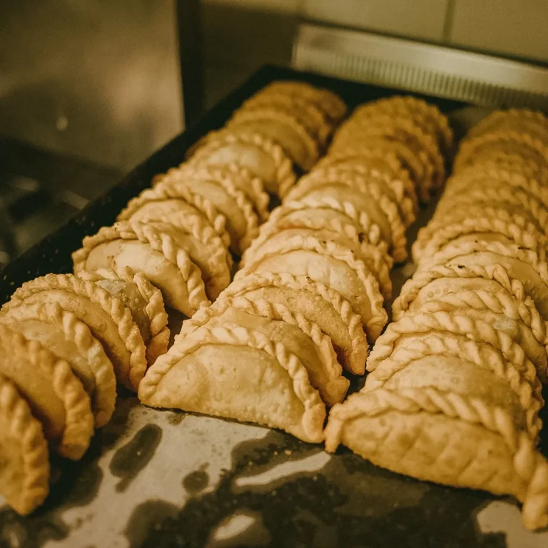 A tray of golden baked empanadas fresh from the oven